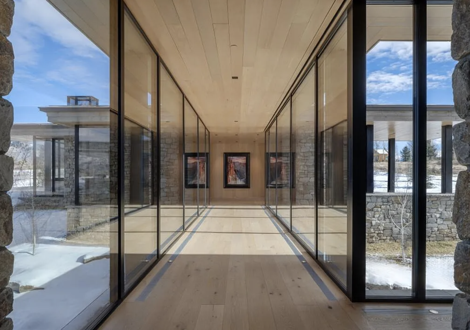 Modern glass hallway with Black Rhino Windows floor-to-ceiling aluminum framed windows